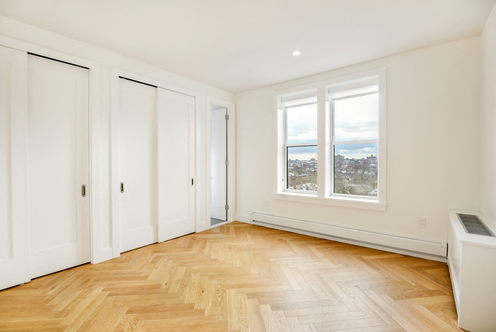 an empty living room with white walls and wood floors